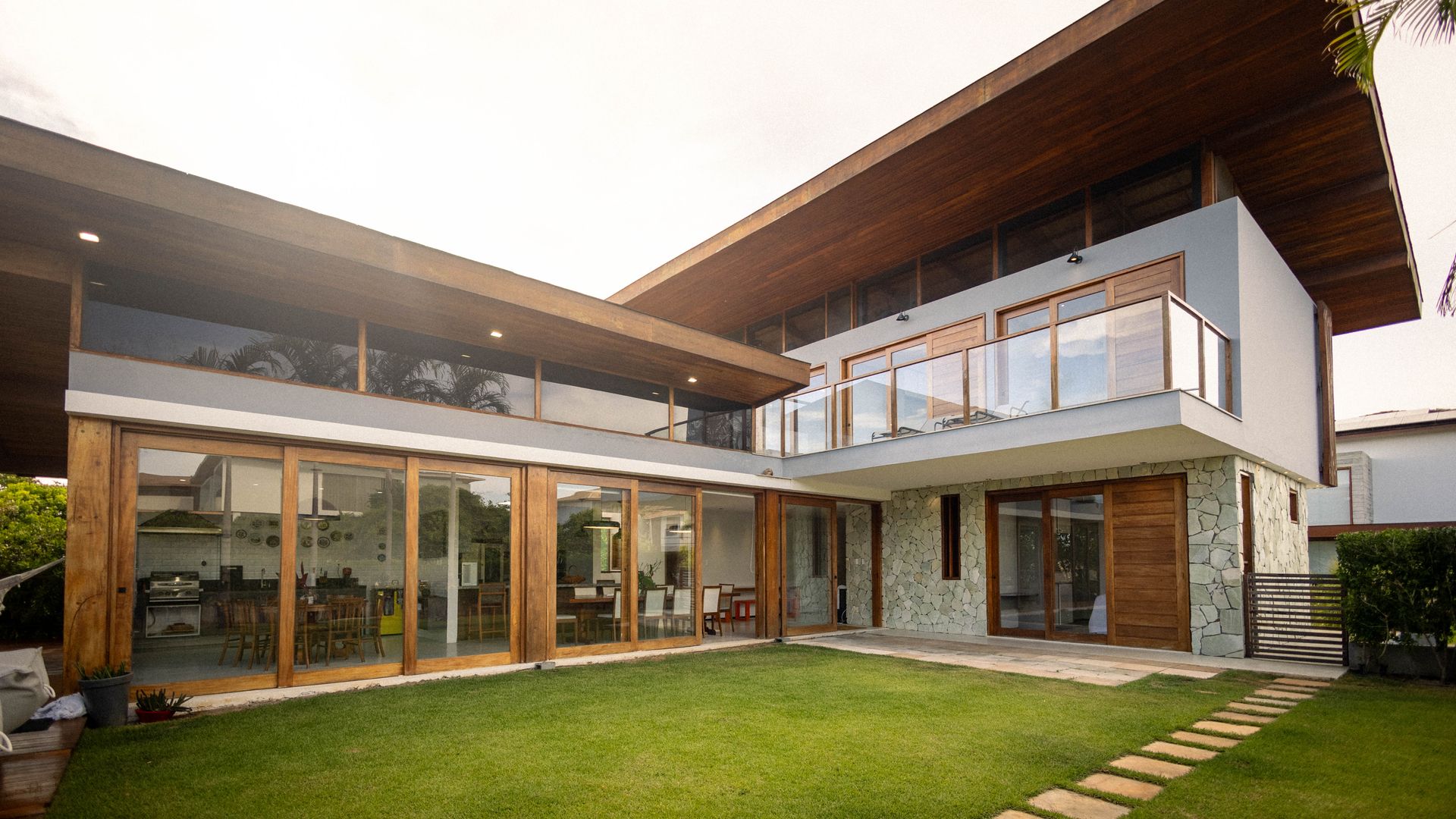 Villa moderna con puertas de cristal correderas y jardín