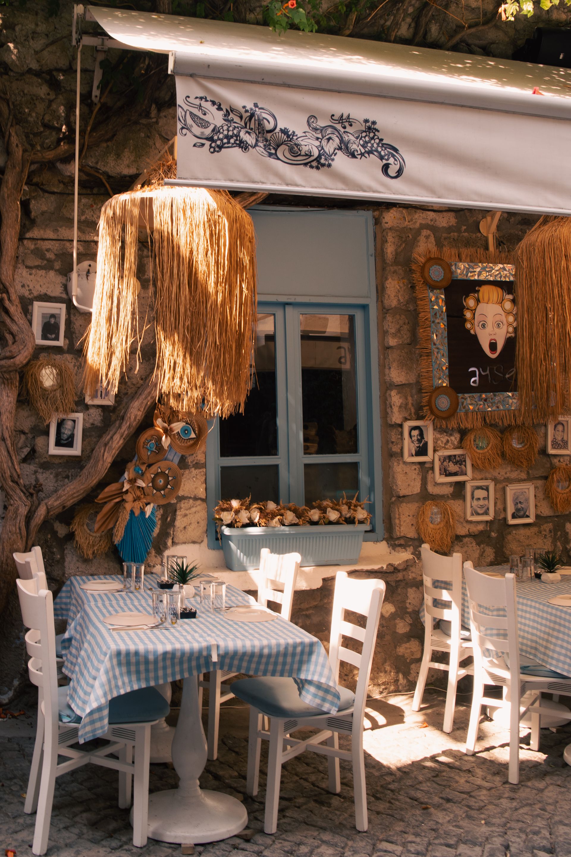 Terraza de una cafetería mediterránea con mesas de cuadros azules